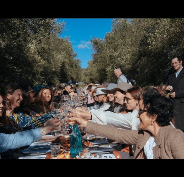 People clinking drink glasses at the Whispering Brook Olive Long Table Luncheon